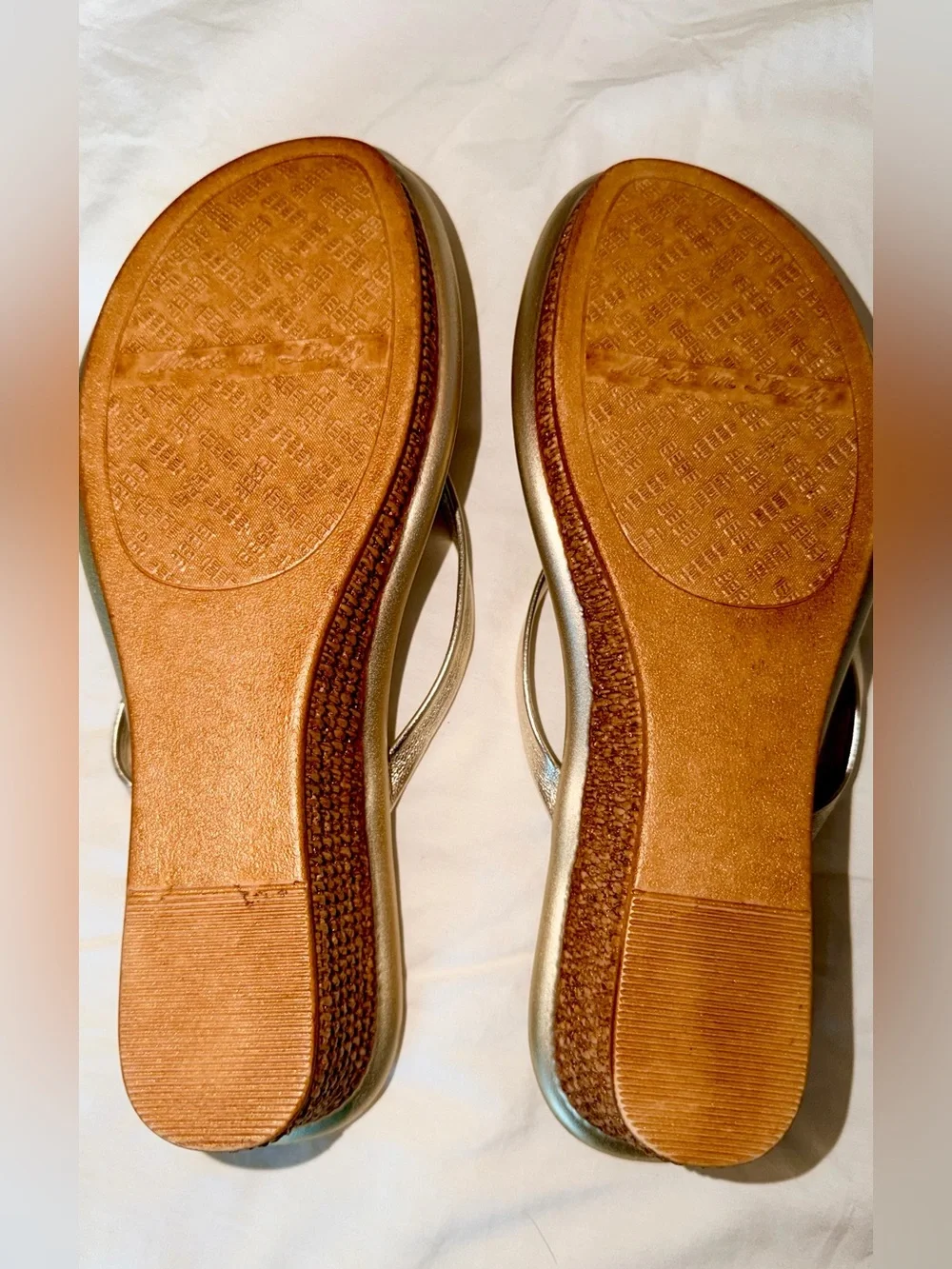 Italian Shoemakers thong wedge sandals feature a metallic gold finish